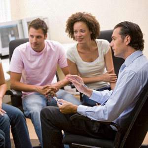 Foto: Gruppe junger Personen beim Diskutieren, angeleitet durch einen Supervisor